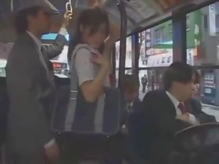 Aziatisch tiener godin betast in bus door groep
