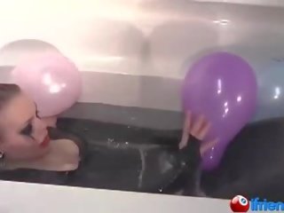 Latex dressed mademoiselle with balloons in a bathtub