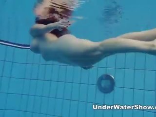 Redheaded galleta nadando desnuda en la piscina